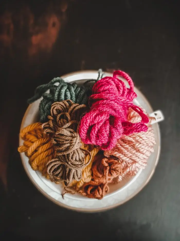 A top view of colorful yarns in a cup, perfect for textile and craft themes.