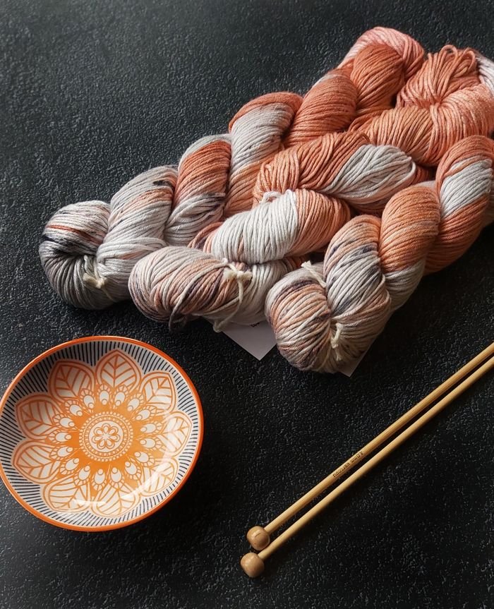 Textured yarn and decorative bowl arrangement creating a warm crafting ambiance.