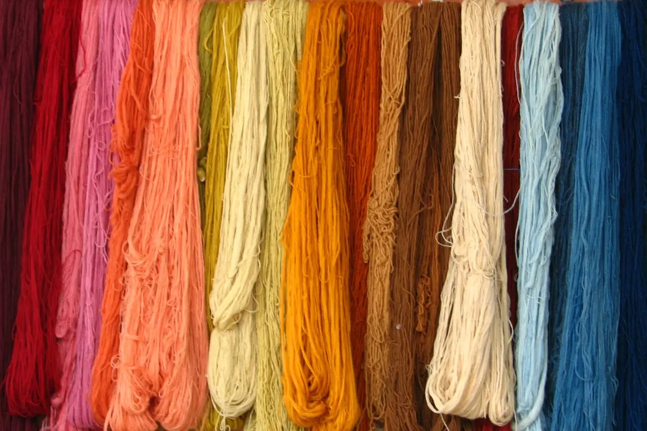 A vivid assortment of textile yarns hanging in rows showcasing diverse colors.